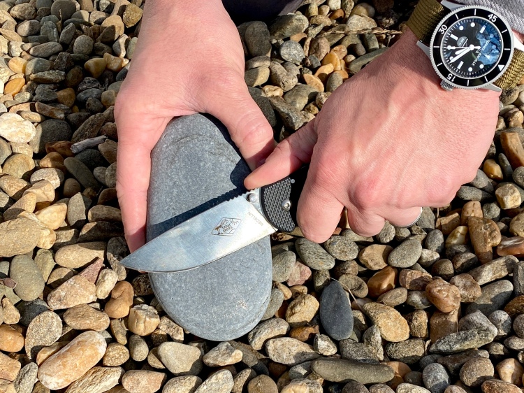 Sharpening a knife with a natural stone.